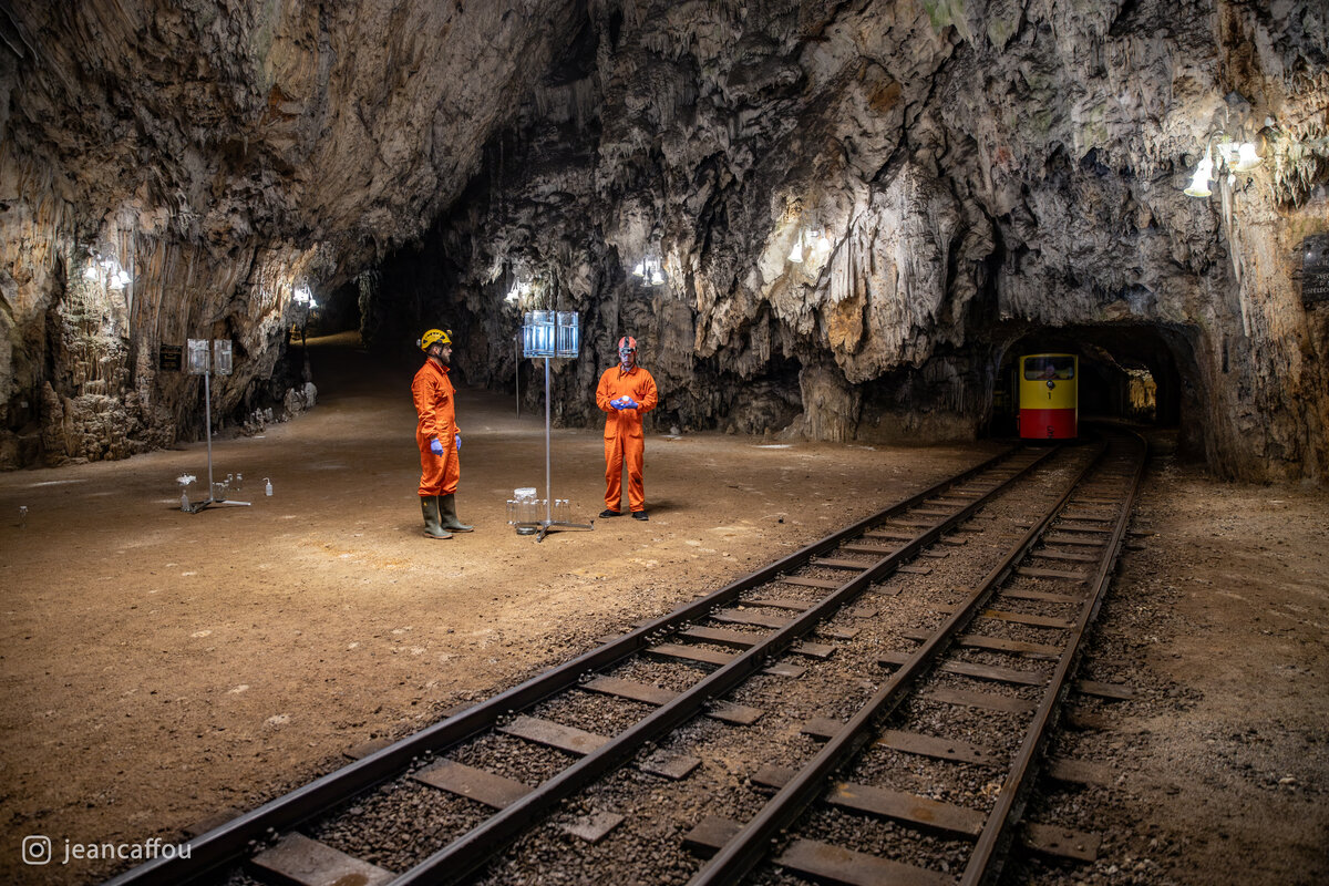 Blaž Kogovšek and Raffaele Bruschi stand beside a sampler as a train approaches through the tunnel into Plesna dvorana.