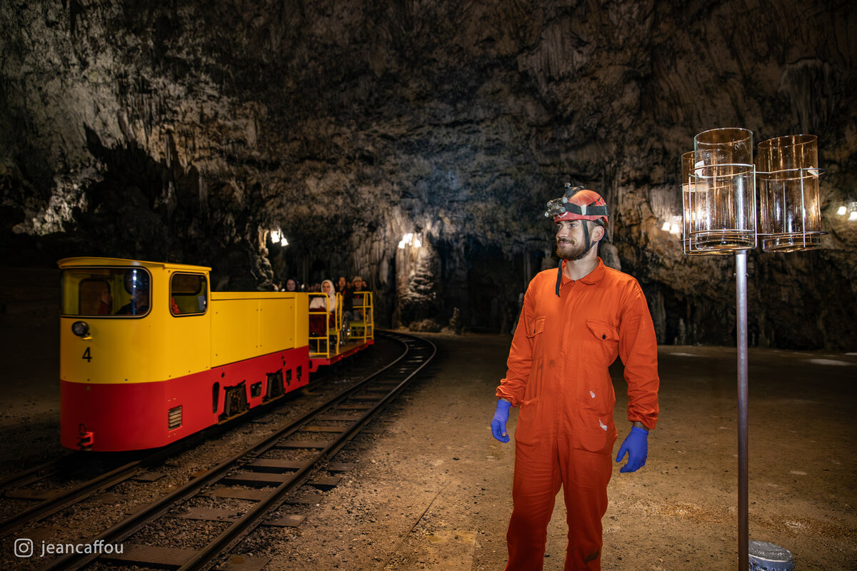 Raffaele Bruschi stands beside the glass deposition collectors in Plesna dvorana as a yellow locomotive passes on the nearby track.